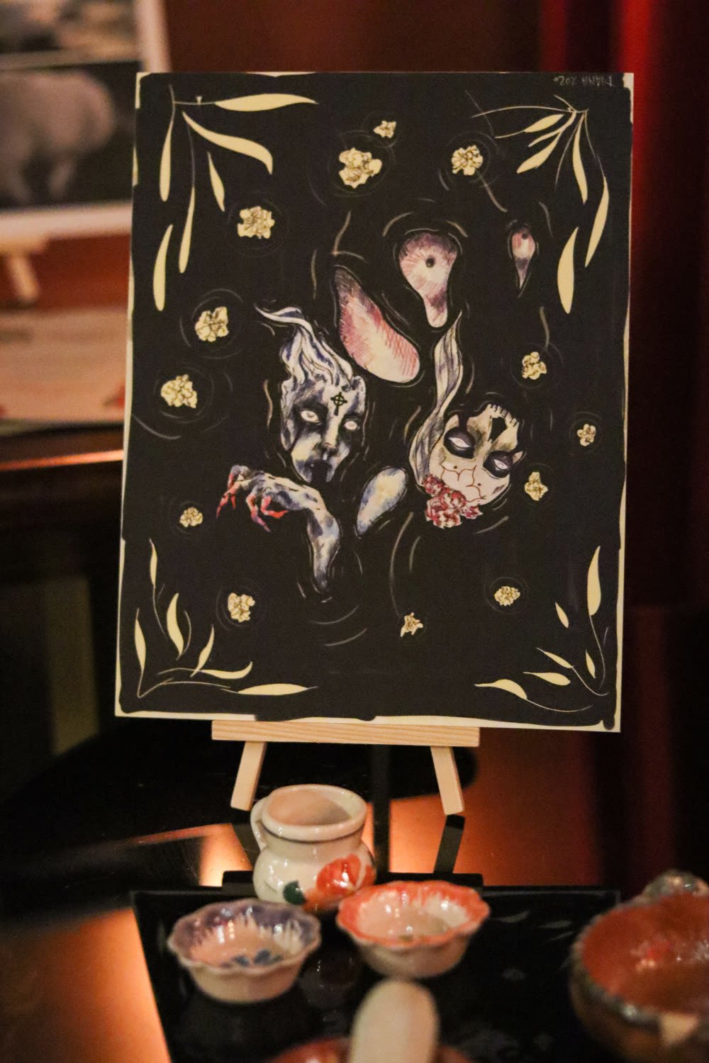 Illustrated artwork displayed on an easel at the exhibition