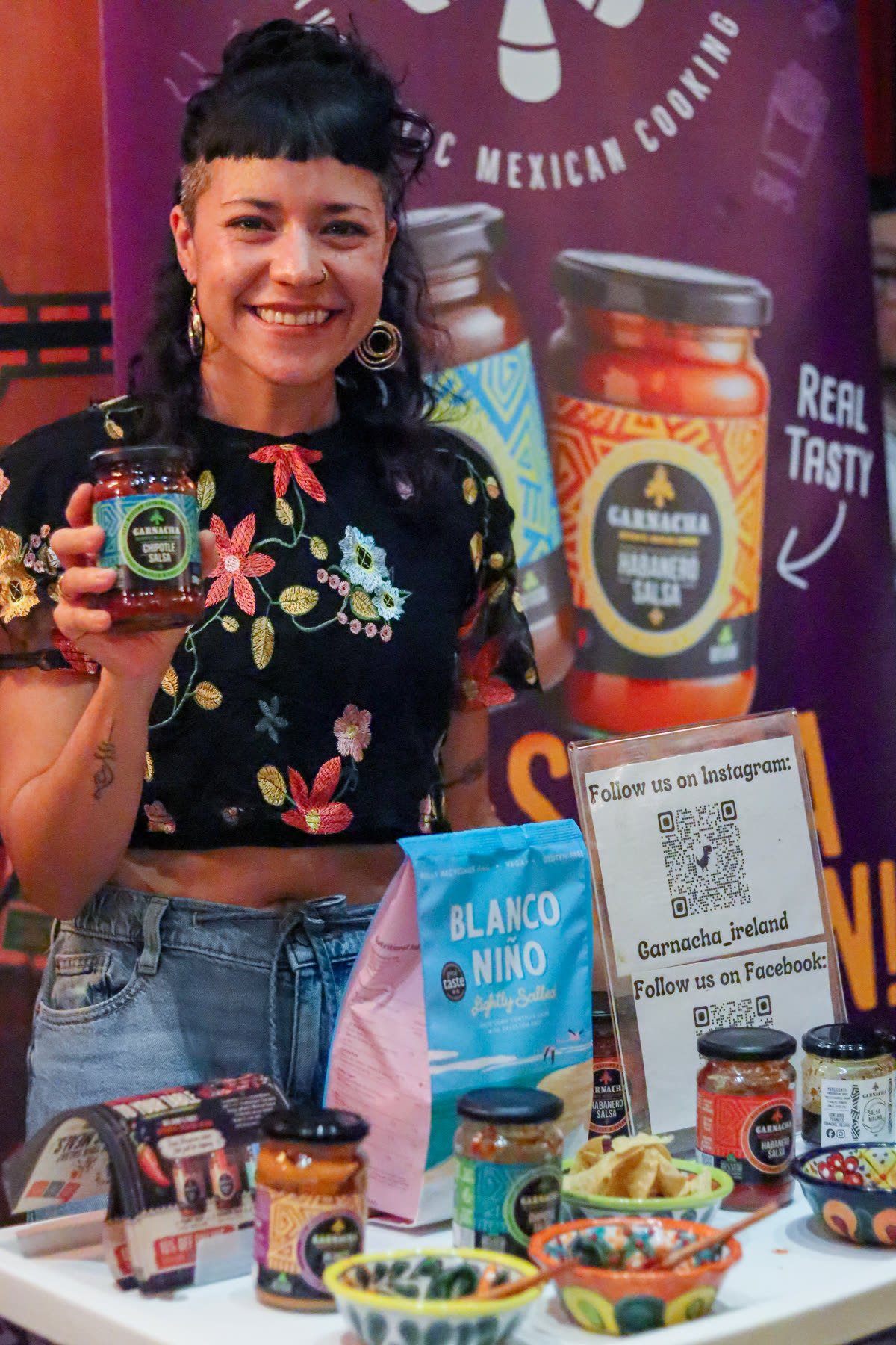 Garnacha vendor showing off a chipotle salsa jar